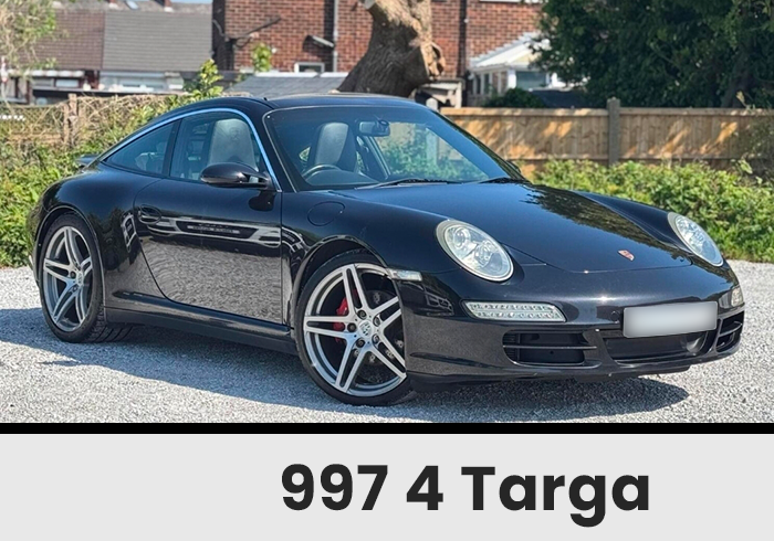 Black Porsche 9974 Targa Parked on a Gravel Driveway with a Brick Wall Backdrop Showing Red Brake Calipers